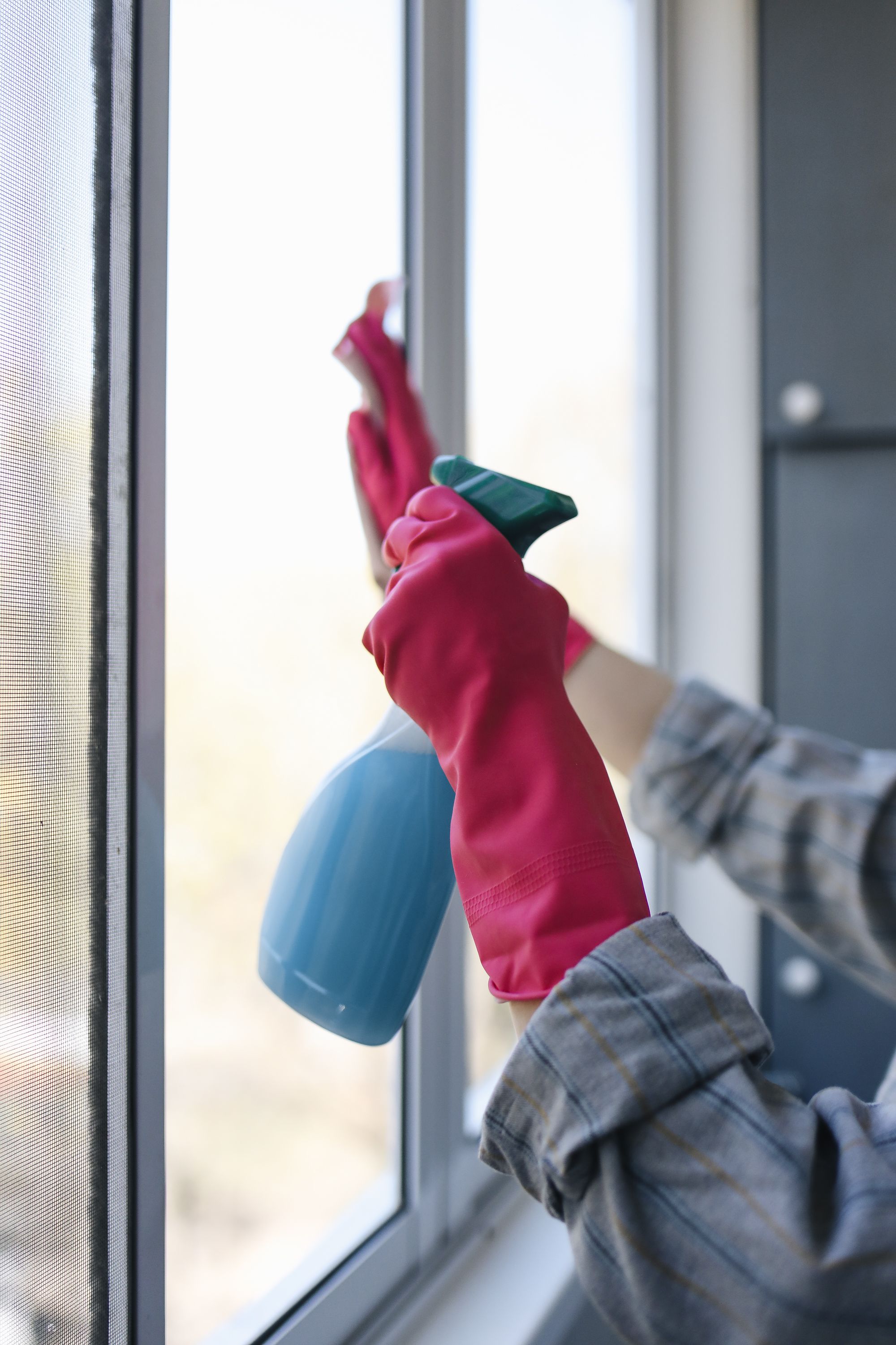 Limpieza de una ventana con paño y pulverizador