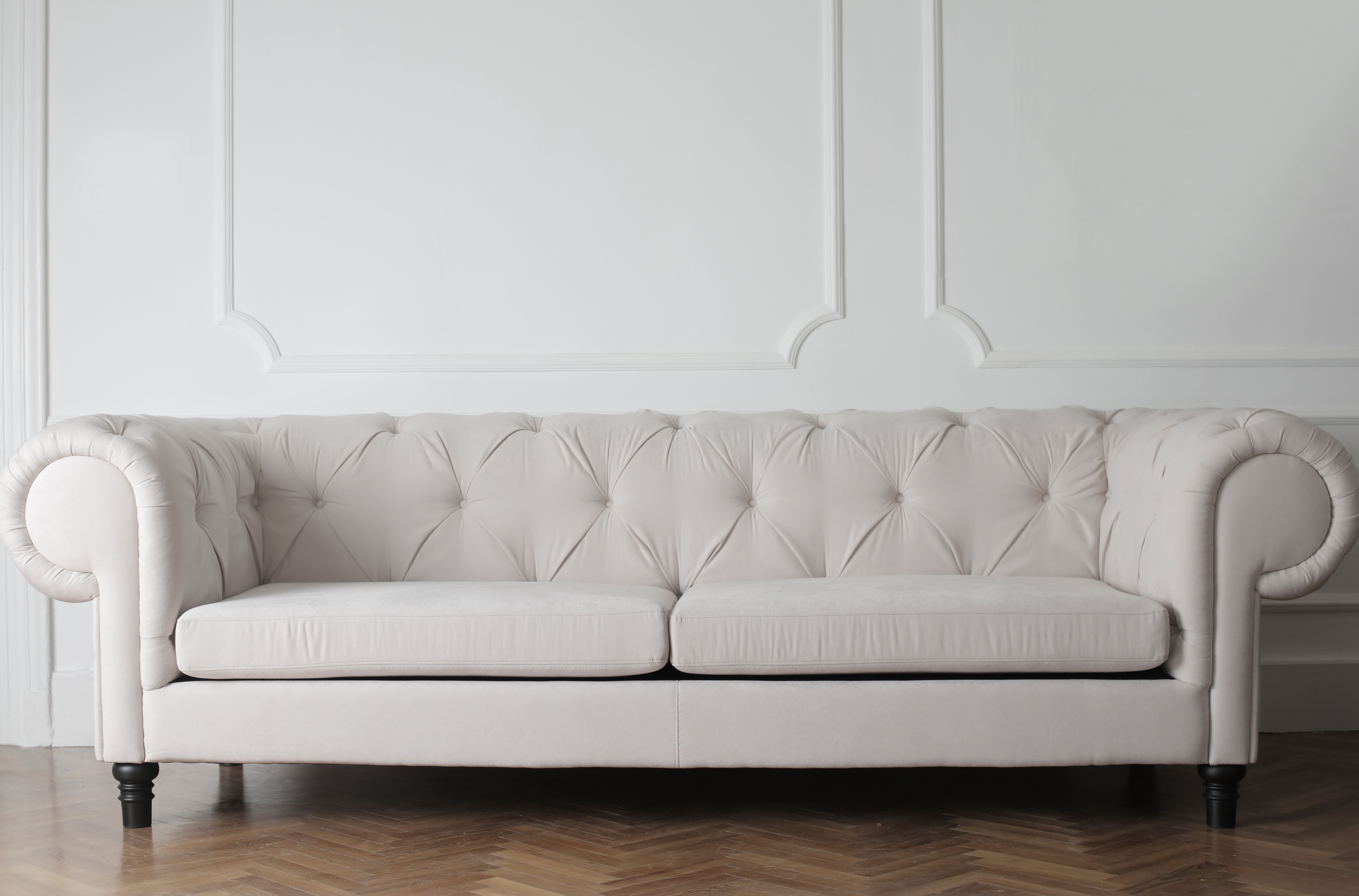Salón cuidado con sofá blanco y suelo de madera
